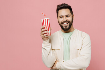 Wall Mural - Young smiling cheerful fun happy caucasian man 20s wear trendy jacket shirt hold soda cola cup of fizzy water isolated on plain pastel light pink background studio portrait. People lifestyle concept.