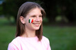 © Svetlana - Happy school girl with cheek painted in Italy flag colors. Educational course, studying Italian. Italian language. Concept of abroad education. Italy football fan. Children score goal at football game