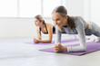© F8  \ Suport Ukraine - Two young fitness women doing yoga asana Low Plank Pose. Ardha Phalakasana