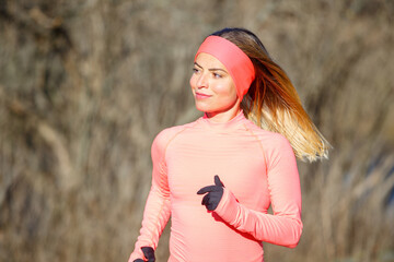 Wall Mural - Close up portrait of young running woman in park in frosty morning.