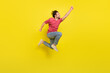 Full length profile photo of hooray beard millennial guy fly wear red t-shirt jeans footwear isolated on yellow background