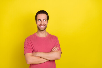 Wall Mural - Photo of positive curious guy crossed arms look empty space wear pink t-shirt isolated yellow color background