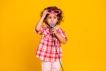 Photo Of Pretty Charming School Girl Dressed Checkered Clothes Singing Microphone Isolated Yellow Color Background