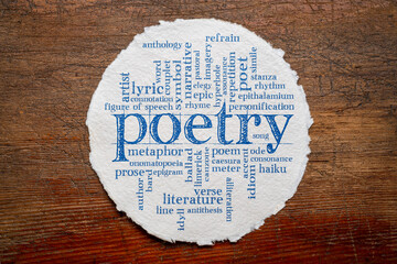 Wall Mural - poetry word cloud on a circular sheet of rough watercolor paper against rustic weathered wood, literature terms