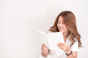 Wall Mural - Young attractive asian student holding books in her arm on white background. School girl with a books to read for homework.