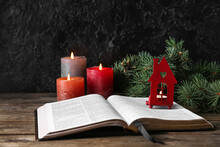 Book With Glowing Candles On Table Against Dark Background. Christmas Story