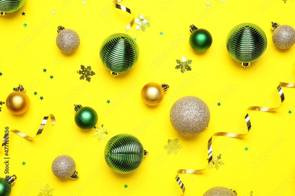 Beautiful Christmas balls and confetti on yellow background