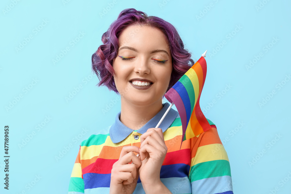 Young woman with LGBT flag on blue background