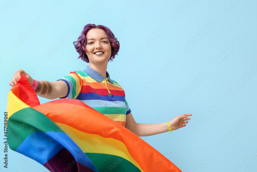 Young woman with LGBT flag on blue background