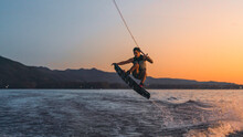 Latino Mas Doing Wakeboarding In A Lake With Mountains In The Background