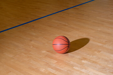 Wall Mural - Basketball on hardwood court floor with natural lighting. Workout online concept. Horizontal sport theme poster, greeting cards, headers, website and app