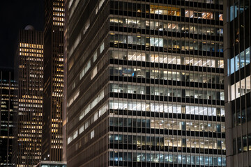 Wall Mural - Modern New York City office building seen at night with lit windows