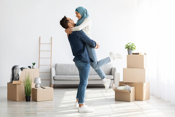 Ecstatic muslim family cuddling while moving to new house