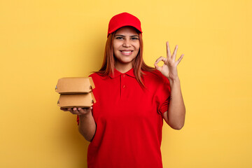 hispanic woman feeling happy, showing approval with okay gesture. take away deliver concept