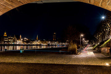 View from a tunnel under a bridge in Frankfurt - Main at night with view to the city at a cold day in winter.