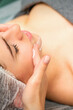 © okskukuruza - Spa facial skincare. Close-up of a young caucasian woman getting spa moisturizing face massage treatment at beauty spa salon