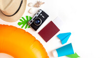 Summer Travel Set Top View: Orange Swimming Circle, Passport, Camera, Straw Hat, Sun Cream