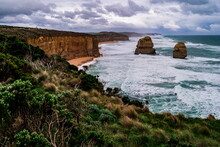 South-East View Of The Twelve Apostles Rock Formations With Short-leaf Plants And Bushes Facing The Extreme Winds Blowing From The Ocean
