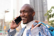 © ADDICTIVE STOCK - Cheerful black man having phone call on street