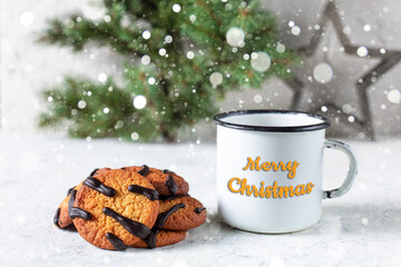 Wall Mural - orange cookies with black stripes and cup of tea with fir tree branch. Christmas dessert. Concept for children new year