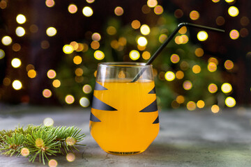 Wall Mural - orange mandarin cocktail in glass with black stripes. Christmas holiday welcome drink. Concept for children new year