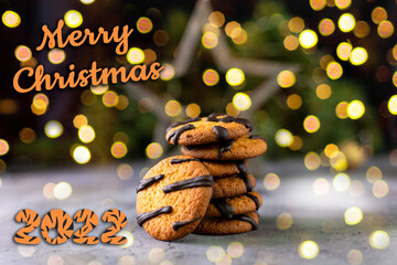 Wall Mural - orange cookies with black stripes and fir tree branches. Christmas holiday sweet dessert. Concept for children new year