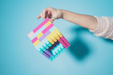 Arm Of Woman Holding Colorful Cube Made Of Pastel Colored Toy Blocks