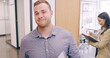 © Yuri A/peopleimages.com - 4k video footage of a cheerful young businessman greeting his colleague as he walks through his office
