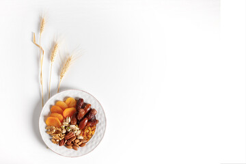 Wall Mural - Dried fruits and nuts mixed plate, ears of wheat.