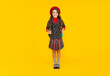 © be free - smiling child in school uniform and beret full length on yellow background, schoolgirl
