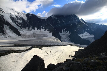 Wall Mural - The circus of the high-mountainous glacier Akkem and Mount Belukha in Altai, large rocky mountains with snow, clouds on the peaks, stones in the foreground, sunset