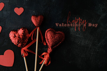 Poster - Red glitter hearts on dark background with happy valentine's day greeting.