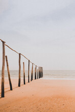 Brown Wooden Poles On Sand Near Sea