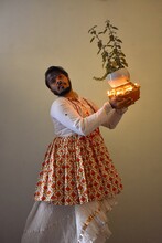 Indian Man In Kathak Dress Holding Plant With Diyas And Dancing