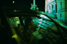 Side View Of Young Man Driving An Old Car At Night