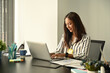 © Prathankarnpap - Charming businesswoman working with laptop at her workplace.