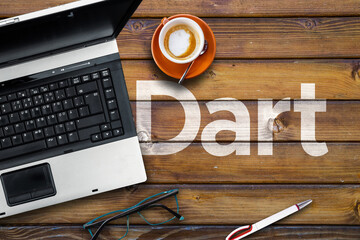 Dart Programming Language. Word Dart on wooden desk  and laptop
