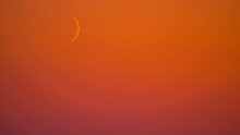 Waxing Crescent Moon Moving In Fiery Orange Sunset Sky. Timelapse