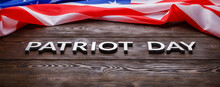 The Words Patriot Day Laid With Silver Metal Letters On Wooden Board Surface With Crumpled Usa Flag