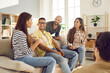 © Studio Romantic - Diverse group of happy young friends having fun together. Smiling mixed race multi ethnic people talking and sharing interesting stories while sitting on the sofa at a friendly get-together at home