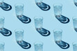 Seamless repetitive pattern with transparent glasses of water with ice cubes on blue background.
