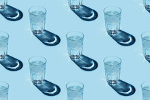 Seamless Repetitive Pattern With Transparent Glasses Of Water With Ice Cubes On Blue Background.