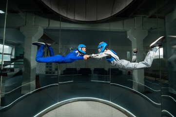 A man and a woman enjoy flying together in a wind tunnel. Free fall simulator