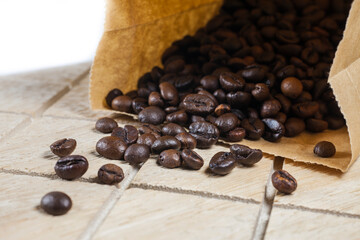 Wall Mural - Coffee beans in a brown paper bag on wooden background.