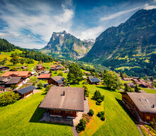 Stunning Summer View From Flying Drone Of Grindelwald Village. Sunny Morning Scene Of Huge Mountains Peaks In Bernese Oberland Alps, Switzerland, Europe. Traveling Concept Background..