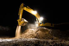 Tractor Excavator Worker Digs A Trench On A Construction Site At Night