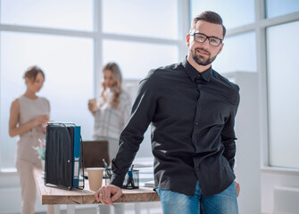 Poster - positive business man sitting near the desktop