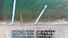 Top View Of Plastic Modular Pontoons In Blue Clear Sea And Tourists Having A Rest On A White Beach. Zoom In Effect