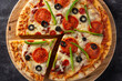 © chandlervid85 - Traditional supreme pizza on black stone	. Close up