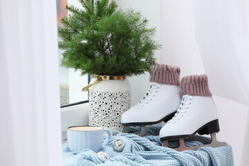 Wall Mural - Pair of ice skates and Christmas decor near window indoors